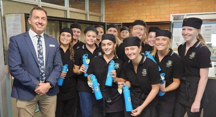 School principal with group of hospitality students in their black event uniforms