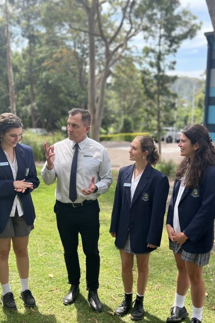 Mr Riley, Principal outside talking with 3 senior students