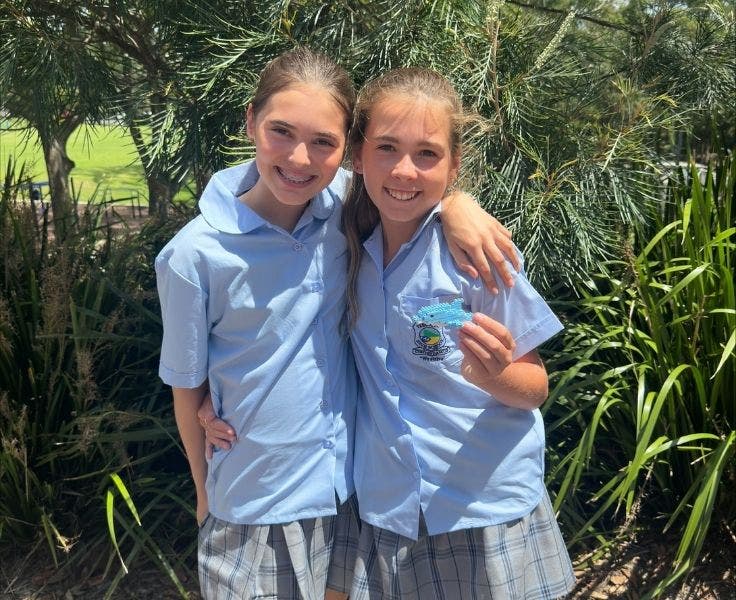 two junior girls student arm in arm